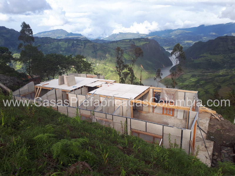 Casa con estructura en madera, habitación con baño y estar TV en segundo nivel